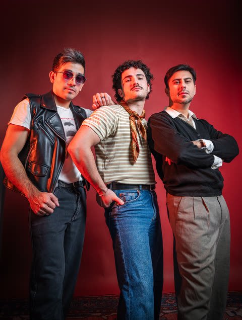 La banda posando frente a un fondo rojo, con camperas de cuero y remeras a rayas